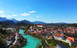 Stadtansicht von Füssen mit Lech und Alpen im Hintergrund.