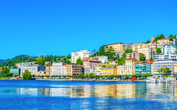 Panoramablick auf die Stadt Lugano am Ufer des Luganersees im Kanton Tessin, umgeben von den Alpen.