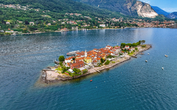 Luftaufnahme der Isola dei Pescatori im Lago Maggiore mit Gebäuden und umliegendem Wasser.
