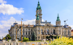 Historisches Gebäude mit Türmen und blauer Kuppel an einem sonnigen Tag.