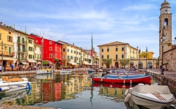 Bunte Häuser und Boote an einem Kanal in einer malerischen Stadt.