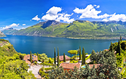 Panorama eines Sees mit Bergen und Häusern im Vordergrund.