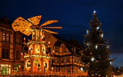 Weihnachtspyramide und beleuchteter Baum vor Fachwerkhaus im Abendlicht