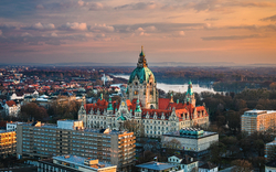 Luftaufnahme des Neuen Rathauses in Hannover bei Sonnenuntergang.