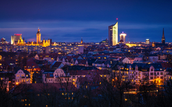 Stadtansicht bei Nacht mit beleuchteten Gebäuden und Wolkenkratzern.