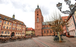 Ein leerer historischer Platz mit Kirche und Fachwerkhäusern.