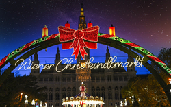 Leuchtendes Tor zum Wiener Christkindlmarkt bei Nacht.
