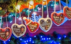 Lebkuchenherzen mit weihnachtlichen Botschaften hängen an einem Stand.
