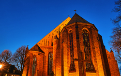 Backsteingebäude einer Kirche bei Dämmerung, seitlich betrachtet