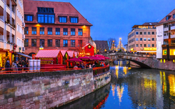 Weihnachtsmarkt am Kanal mit Brücke in der Dämmerung