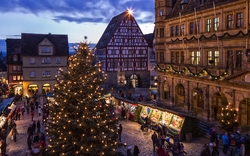 Marktplatz mit Weihnachtsmarkt und beleuchtetem Baum in Rothenburg ob der Tauber.