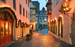 Weihnachtlich geschmückte Altstadtgasse bei Dämmerung.