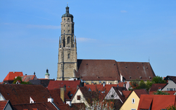 Kirchturm in einer Stadtlandschaft mit roten Dächern