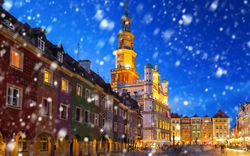 Bunter Marktplatz mit schneebedecktem Himmel in einer historischen Stadt bei Dämmerung.