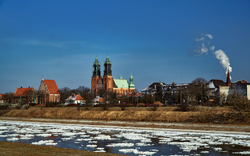 Fluss mit Eisschollen vor historischer Kathedrale bei klarem Himmel.