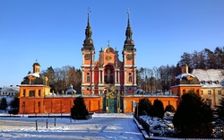 Barocke Basilika in winterlicher Landschaft mit blauem Himmel.