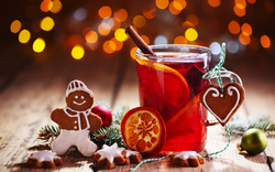 Heißer Glühwein mit Zimt und Lebkuchen auf einem Holztisch.