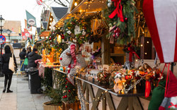 Weihnachtsmarktstände mit festlicher Dekoration und Lichtern.