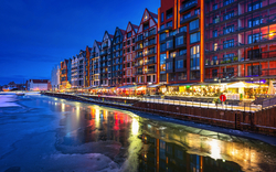 Gdańsk im Winter in der Abenddämmerung mit beleuchteten Gebäuden am Flussufer