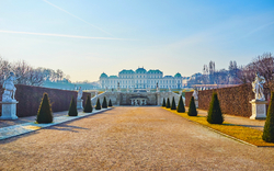 Schloss Belvedere in Wien mit Garten und Statuen im Vordergrund.