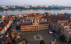Stadtplatz mit historischen Gebäuden und Fluss im Hintergrund.