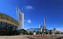 Platz mit Brunnen und modernen Gebäuden unter blauem Himmel