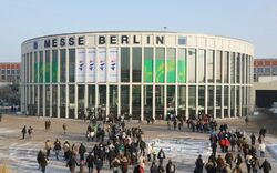 Eingang der Messe Berlin mit vielen Menschen im Winter.