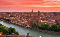 Stadtansicht bei Sonnenuntergang mit Fluss im Vordergrund