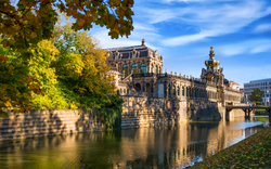 Barocker Gebäudekomplex am Wasser an einem sonnigen Tag mit blauem Himmel.