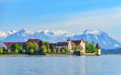 Inselstadt Lindau am Bodensee vor schneebedeckten Alpen im Frühling.