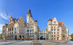 Historisches Gebäude mit Turm, blauer Himmel im Hintergrund.