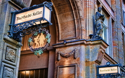 Eingang zu Auerbachs Keller mit dekorativem Schild und Skulptur an der Fassade.